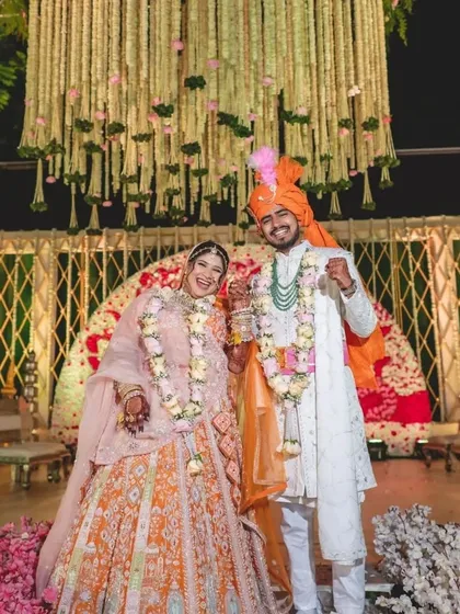 A happy couple captured against a backdrop of cascading floral strings. I designed this setting to feel joyous and celebratory, with a ceiling of flowers that frames their smiles perfectly.