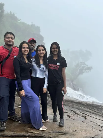 Friends posing at the misty edge of Bandaje Falls.
