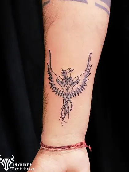 A fine-line phoenix on the wrist, poised to take flight. This minimalist version of the powerful symbol is both elegant and meaningful.