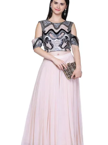 A contemporary cold-shoulder crop top with bold, graphic embroidery paired with a simple light pink pleated skirt. This outfit is a great example of the fusion wear available in our collection, perfect for a cocktail party.