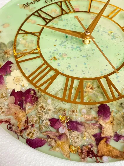 Another angle of the orchid preservation clock, showing the texture of the different flowers and the shimmer of the light green resin.