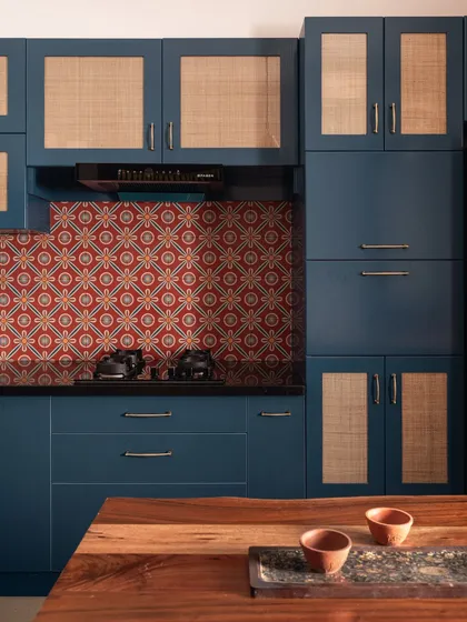 This kitchen is a whisper of South India, with its deep monsoon blues, terracotta-patterned tiles, and natural cane shutters. It’s a space designed with quiet strength, holding fast to what endures rather than chasing trends.