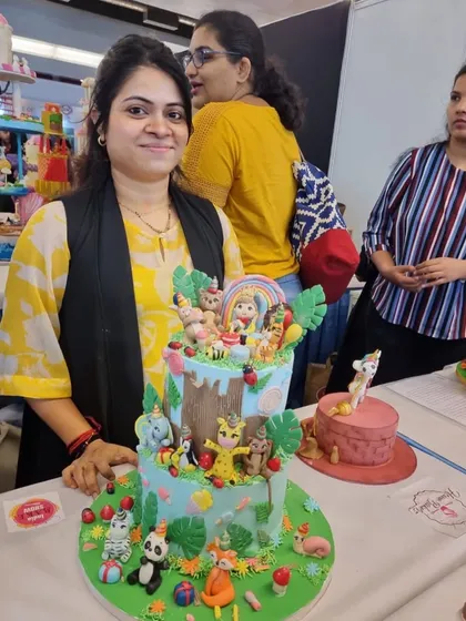 Me with my two-tier animal party cake at the competition, exhausted but happy after two sleepless nights.