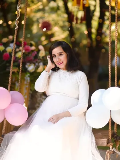 We can create a lovely, celebratory feel for your shoot. Here, the mom to be is glowing on a decorated swing, surrounded by balloons, perfect for a baby shower theme.