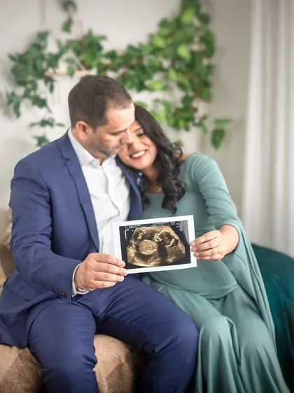 A beautiful way to announce the journey: the couple holds up their baby's first picture, the sonogram. This shot adds a lovely narrative element to their bohemian-themed studio maternity session.
