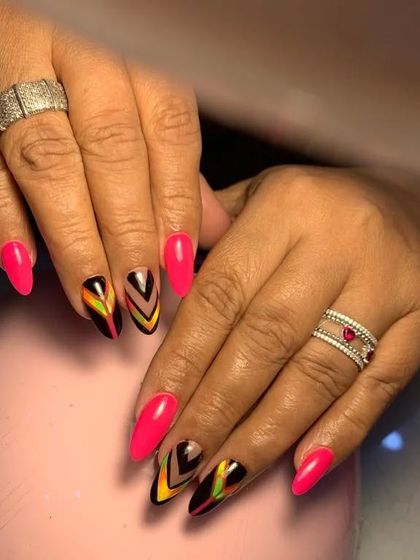 A bold and vibrant set with hot pink nails and accent nails featuring a colorful chevron pattern.