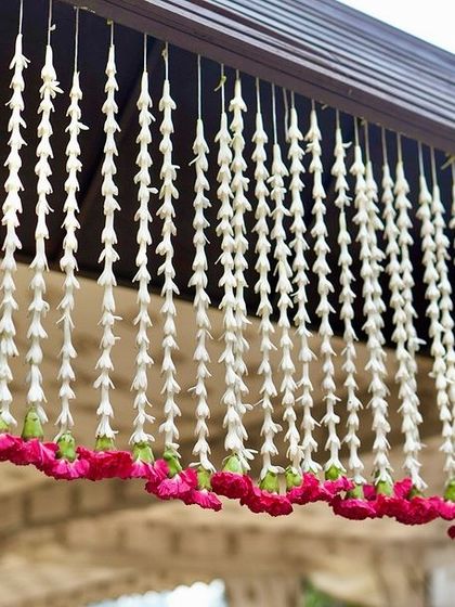 Strings of fragrant tuberose flowers hang elegantly, a classic element in South Indian wedding decoration that adds timeless beauty.