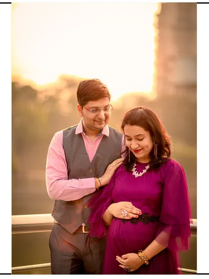 A beautiful golden hour shot of a couple on a balcony, capturing a warm and intimate moment.