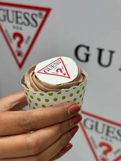 A guest holding one of our custom GUESS cupcakes. It's a great way to integrate a brand's identity directly into the culinary experience, making it memorable for everyone.