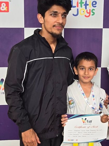 With another young student who won a medal, celebrating his hard work and achievement.