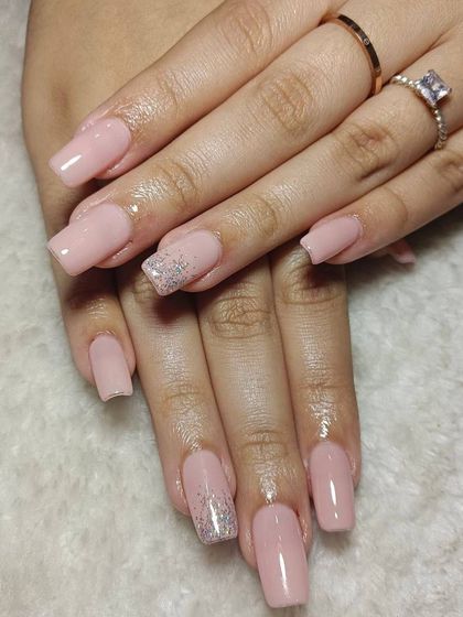 A classic nude pink set on square-shaped extensions, with a subtle silver glitter ombré on the ring fingers. It's a perfect way to add a touch of glam to a minimal look.