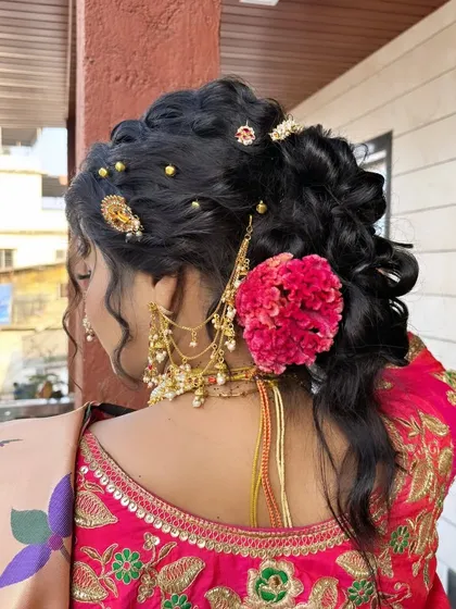 A detailed view of a traditional bridal hairstyle. This intricate bun is adorned with fresh flowers and gold accessories, a classic choice for a Maharashtrian wedding.