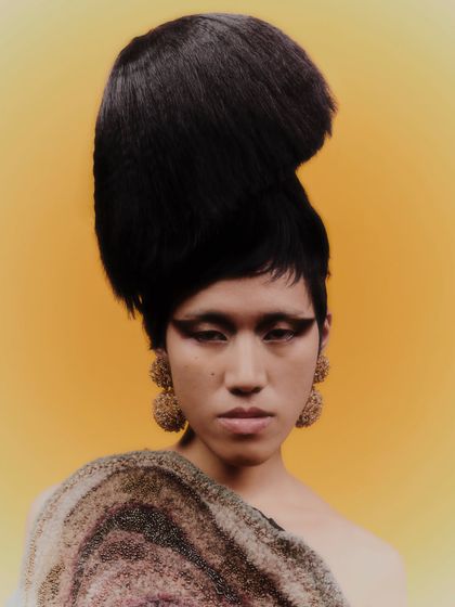 A closer portrait from the same series, allowing for a better view of the texture and detail of the large, beaded earrings.