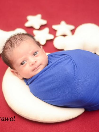 This awake and curious newborn, wrapped in blue, seems to be looking right at the camera. I work at your baby's pace, capturing both sleepy and alert moments as they happen naturally.