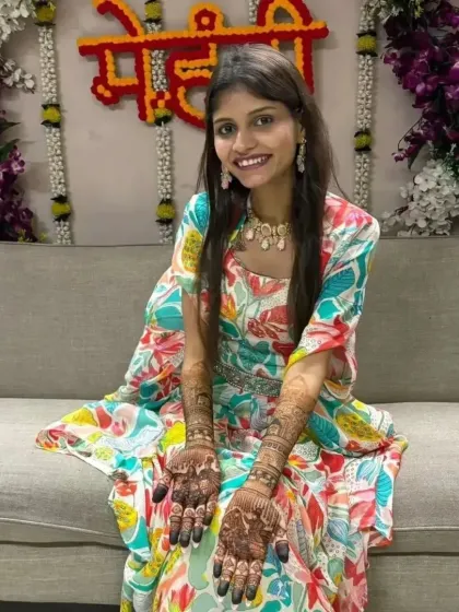A radiant bride-to-be, all smiles as she shows her full bridal mehandi.
