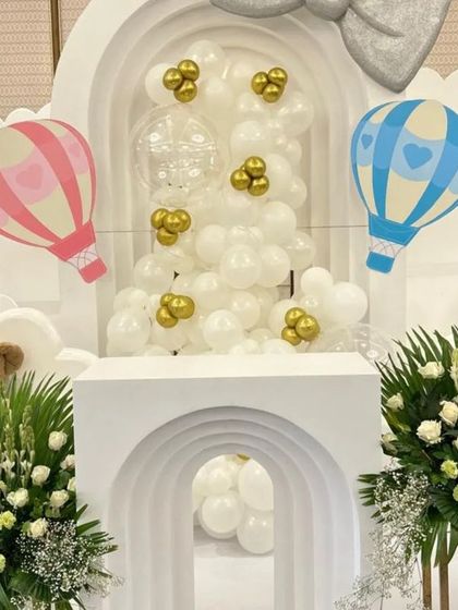 Another angle of the hot-air balloon baby shower decor, highlighting the layered cloud backdrop and the large bow accent, which add depth and whimsy to the design.