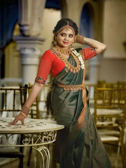 This model showcases a traditional look with a kasu malai set, complete with a matching vaddanam and jhumkas, perfect for a classic muhurtham.