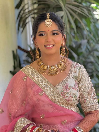 A happy portrait of the bride, her floral updo completing her pretty in pink look.