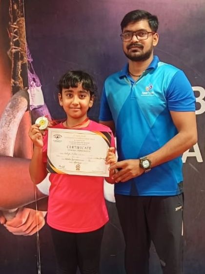 This student proudly displays the medal and certificate she won.