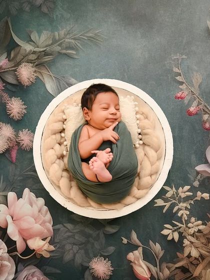 An overhead view of the dark floral theme, showcasing the artistic arrangement and the baby's sweet, sleeping face.