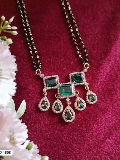 A statement mangalsutra with a pendant featuring large green stones. This piece is perfect for those who want a modern mangalsutra that is also bold and eye-catching.