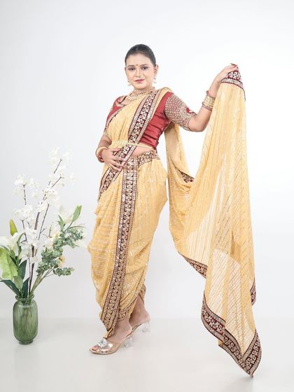 A soft beige or cream-coloured Nauvari with a maroon border, offering a subtle and elegant option for daytime events.
