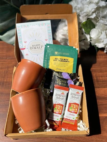 A perfect tea-time hamper, this budget-friendly gift pack includes two traditional kulhads, paper boat chikkis, herbal tea bags, and cookies, all for just Rs. 440 with free shipping.