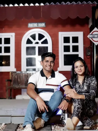 A fun shot on the railway tracks of the station set. This pose adds a playful element to the travel-themed pre-wedding photoshoot.