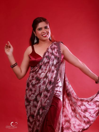 A playful and dynamic shot that captures the joy of the moment. The movement of the saree adds a beautiful flow to this vibrant studio portrait.
