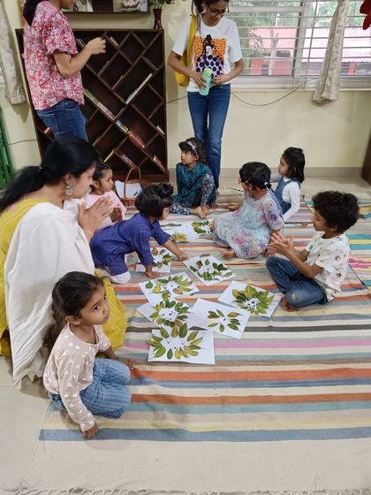 Children admire the leaf-art they created. It's wonderful to see them appreciate their own work and the work of their friends.