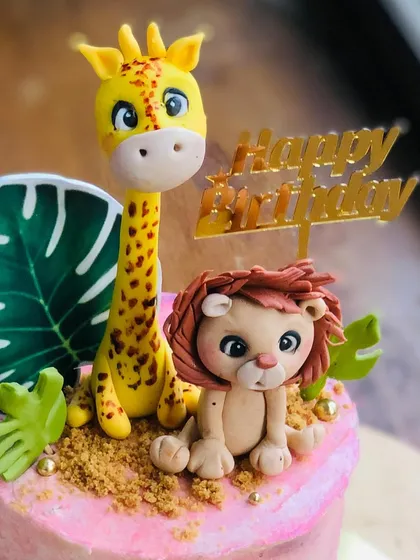 A close-up on the adorable fondant giraffe and lion toppers from the jungle cake.