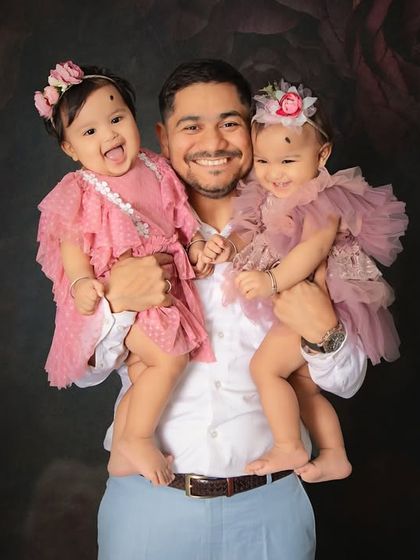 A proud papa with his twin girls. The joy on his face is priceless. Capturing the special bond between a father and his children is one of our favorite things.