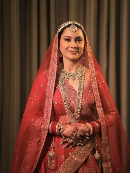 A lovely portrait of the bride. Her subtle makeup, with a focus on glowing skin, allows her beautiful smile and traditional red attire to take center stage.