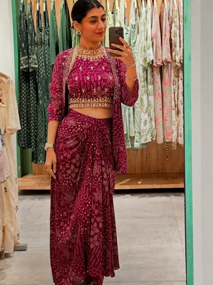 Trying on a different festive look with a printed crop top, draped skirt, and jacket, showcasing a trendy ethnic style.