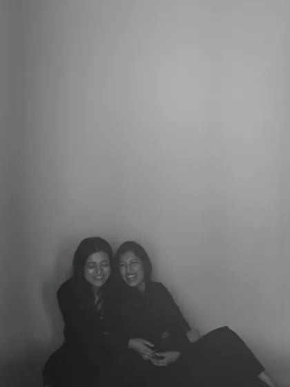 A soft, grainy photo of two friends sharing a laugh. This image feels like a cherished memory, a testament to the warmth of their bond.