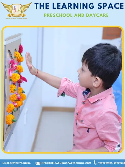 A child proudly displays his flower art. Completing a project from start to finish gives children a wonderful sense of accomplishment and pride.