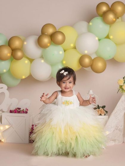 This happy little girl is all smiles as she celebrates turning one in her beautiful layered dress.