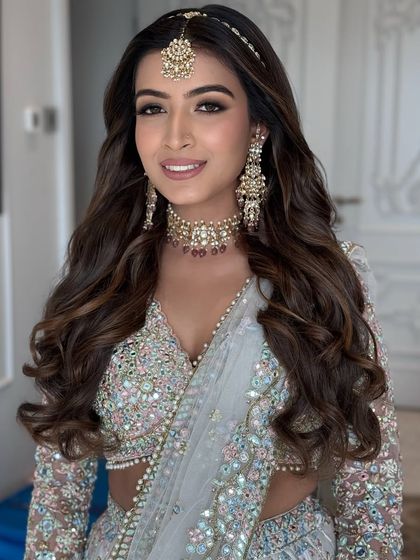 A classic open hairstyle with voluminous waves, perfect for a bride on her wedding day or for a grand reception. I styled this look to be full and flowing, beautifully framing the face and complementing the traditional jewelry.