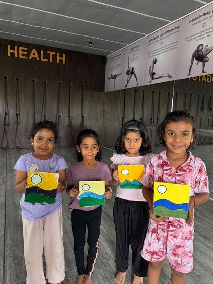 Four young artists proudly displaying their paintings from the summer camp. It is wonderful to see their unique interpretations and the joy of creation.