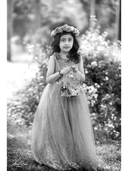 Brishka as a fairytale princess, presented in elegant black and white. The monochrome tones highlight the texture of her sparkling dress and the delicate details of the floral crown.