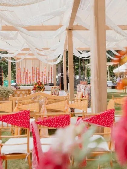 A wide view of the seating at the 'Rajasthani Folklore' Mehendi, with colorful bandhani fabric tied to the chairs.