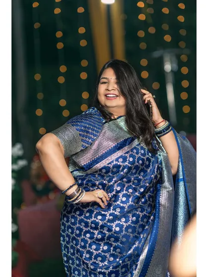 A guest strikes a pose on the dance floor, her beautiful blue saree and joyful expression making for a great candid shot.