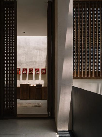 A passage in the GAIA house, where wooden screens and open corridors create a beautiful play of light and shadow. This view looks towards the puja room, which is designed as a calm, meditative space.