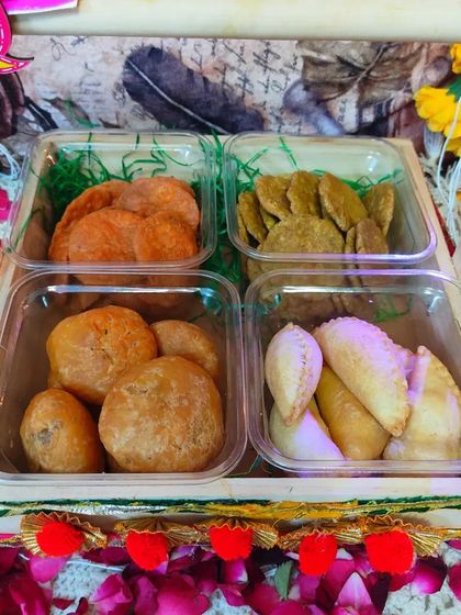 A top-down view of the delicious assortment in the Holi hamper: Beetroot Mathri, Spinach Mathri, Dal Kachori, and Gujiya.