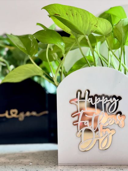 A close-up of the acrylic holders I use for the Father's Day plant and cake hampers. They come with messages like 'Happy Father's Day' or 'I love you' in elegant gold script.