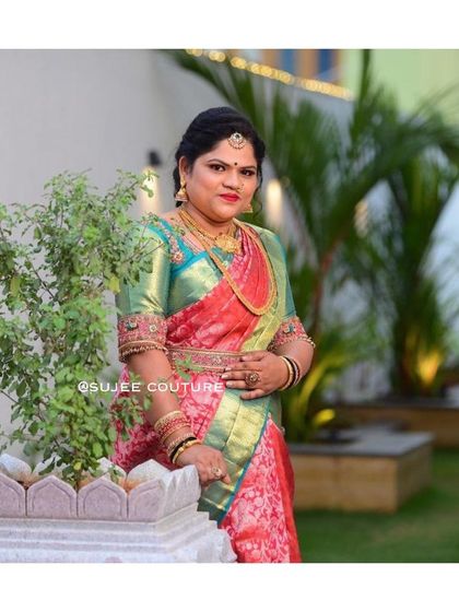 A beautiful portrait of a client in her custom bridal attire. The green silk blouse with intricate gold and red embroidery provides a lovely contrast to her red and gold brocade saree.