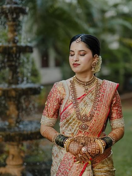 My beautiful client-turned-family, Chethana, looks timeless in this white and pink Kanchipuram saree. I designed a heavily handcrafted bridal blouse with intricate zardozi work to complement the saree's elegance for her special day.