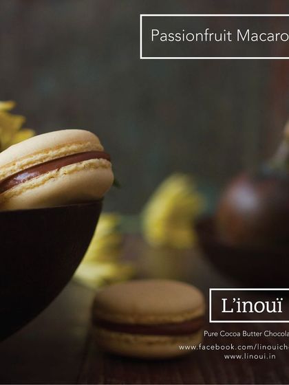 Our Passionfruit Macaron, a delightful confection with a tangy and sweet filling. The moody lighting in this shot emphasizes the rich, indulgent quality of this unique flavour.