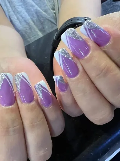 A glamorous take on the French manicure. These coffin-shaped nail extensions feature a rich purple base with elegant white lines and a sparkling silver glitter finish on the tips.