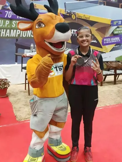 Samriddhi posing with the tournament mascot after winning a bronze medal in the U-15 category at the UP State Championship.